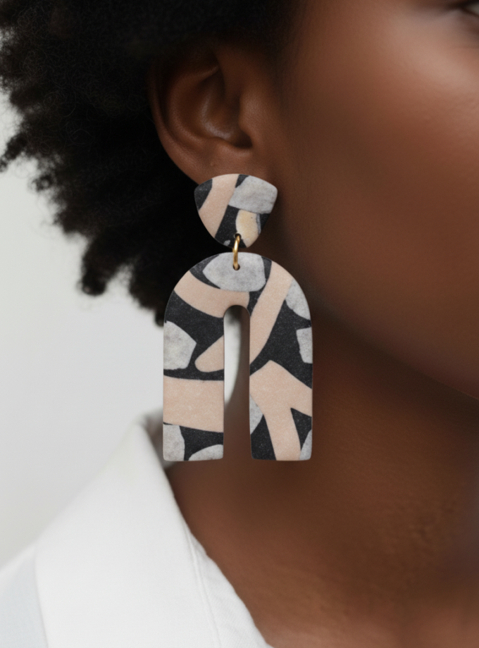 Close-up of Archéa polymer clay earrings with unique marbled texture.
